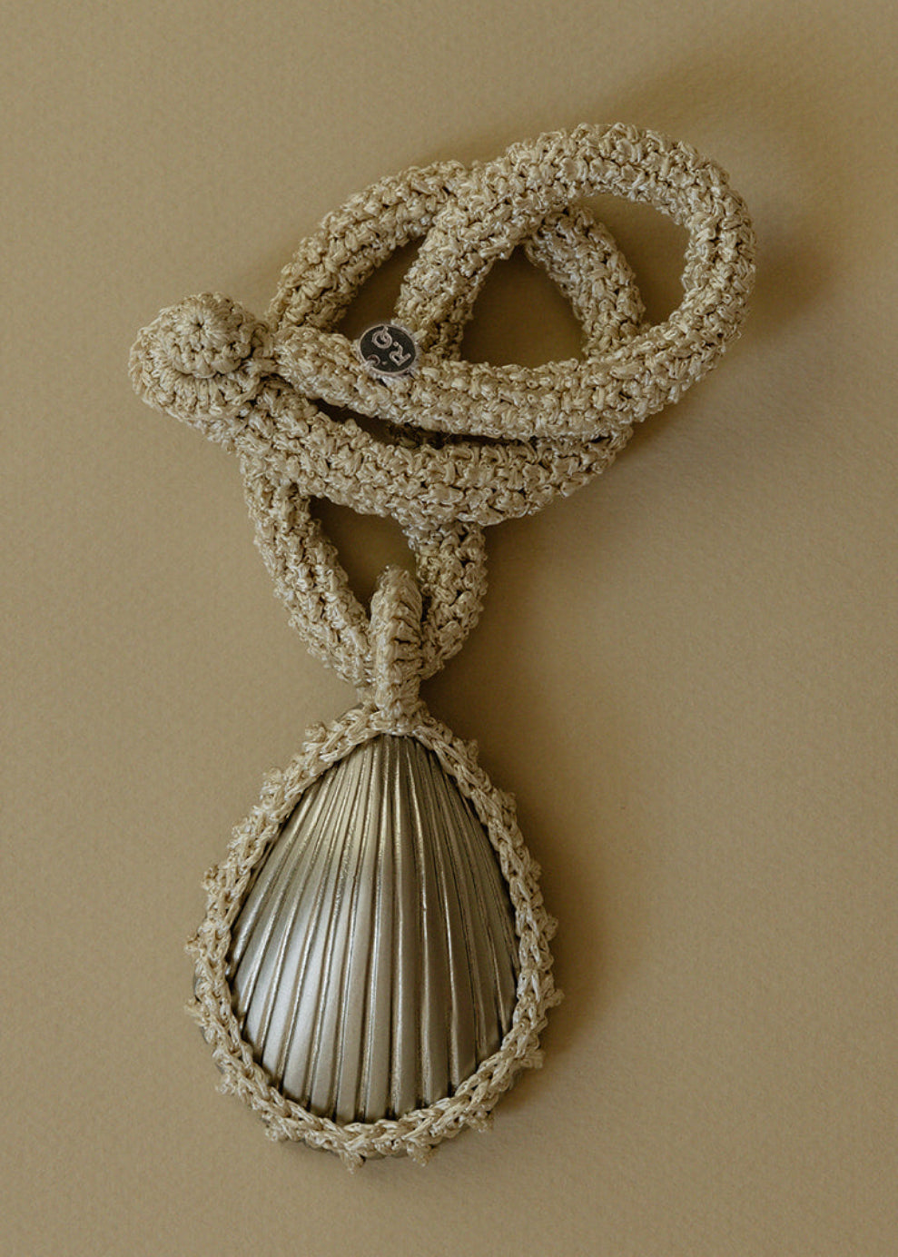 Hand crocheted necklace featuring a silver-plated bronze seashell pendant