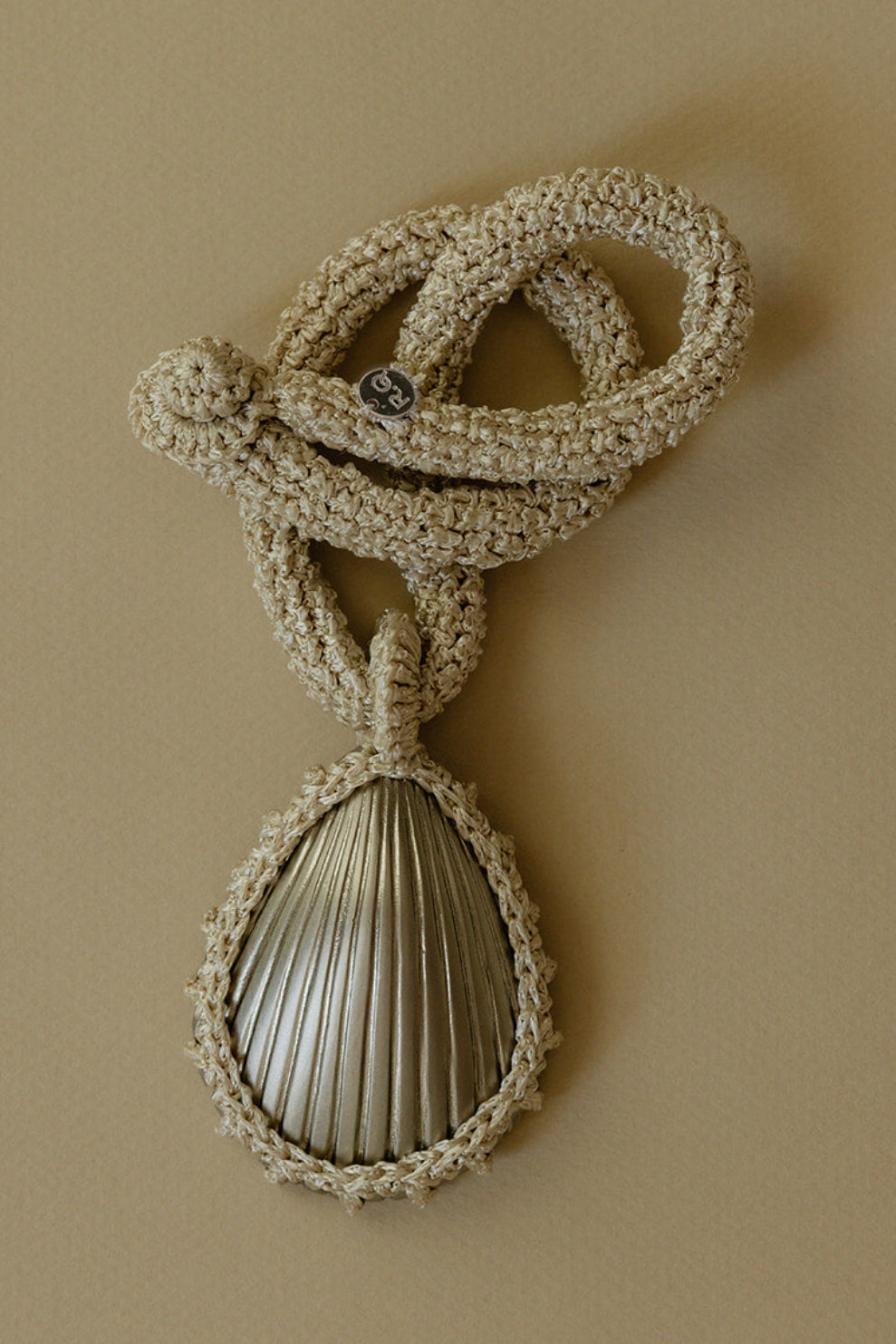 Hand crocheted necklace featuring a silver-plated bronze seashell pendant