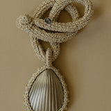 Hand crocheted necklace featuring a silver-plated bronze seashell pendant